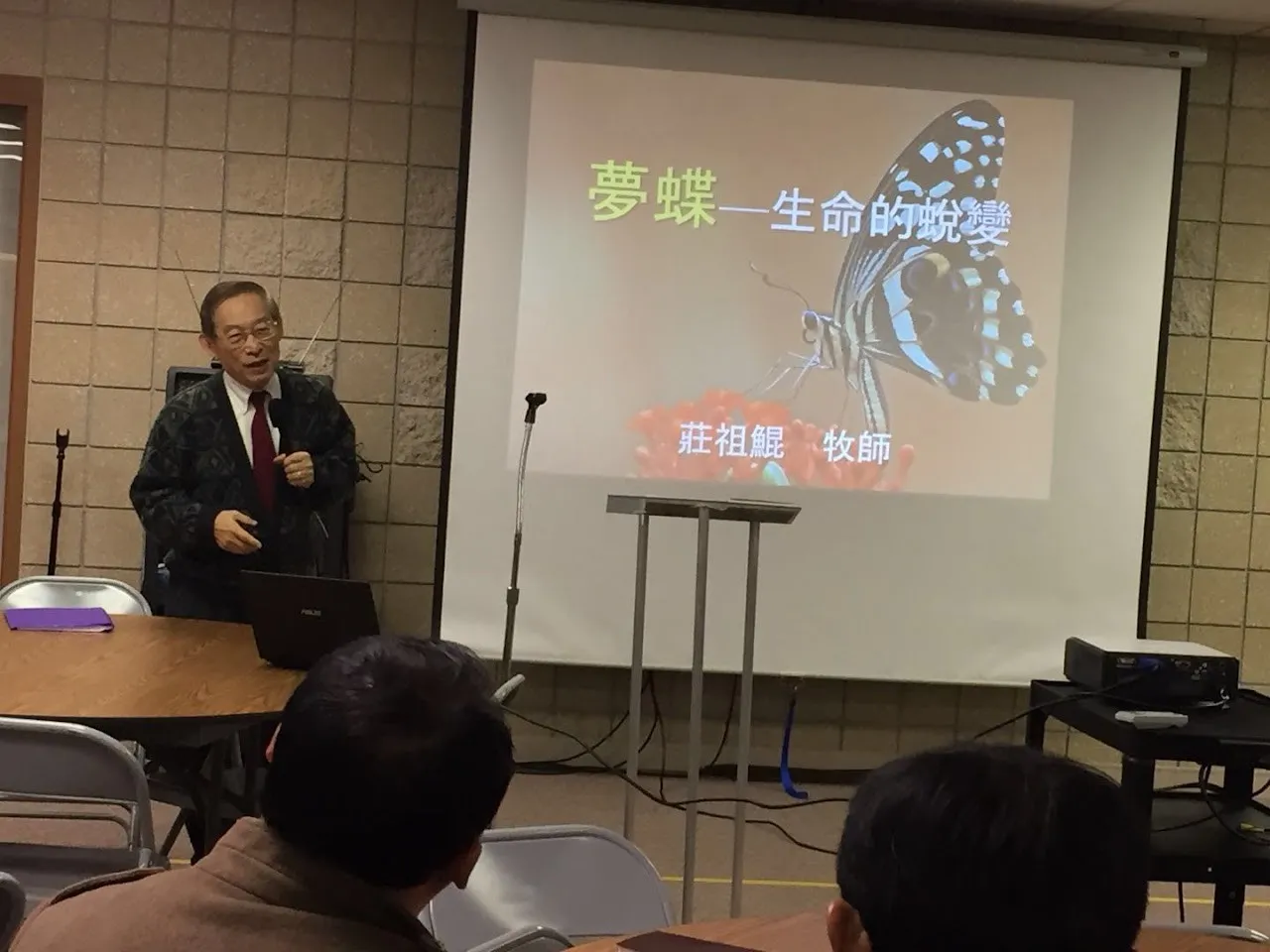 Pastor Tsu-Kung Chuang presenting; the slide reads 夢蝶—生命的蛻變, 莊祖鯤 牧師